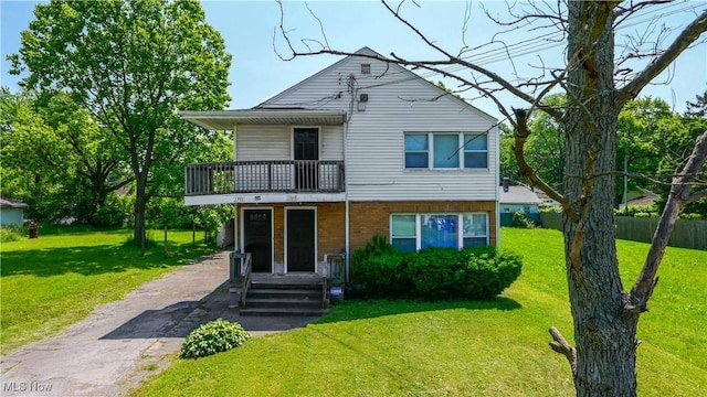 1369 Adelaide Ave SE, Warren, OH 44484 - view of front facade featuring a balcony, a front lawn, driveway, and brick siding