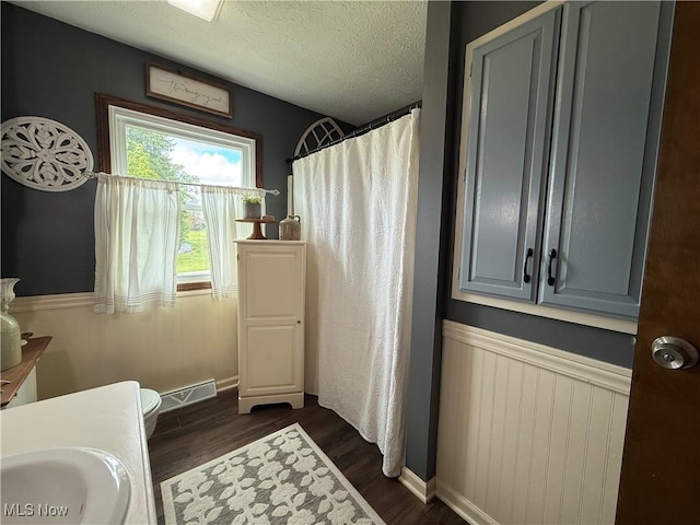 14003 N Highview Dr, Dalton, OH 44618 - full bathroom featuring wood finished floors, curtained shower, a textured ceiling, and a wainscoted wall