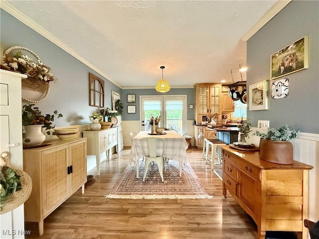 14003 N Highview Dr, Dalton, OH 44618 - dining room featuring ornamental molding, light wood-type flooring, a textured ceiling, and a wainscoted wall