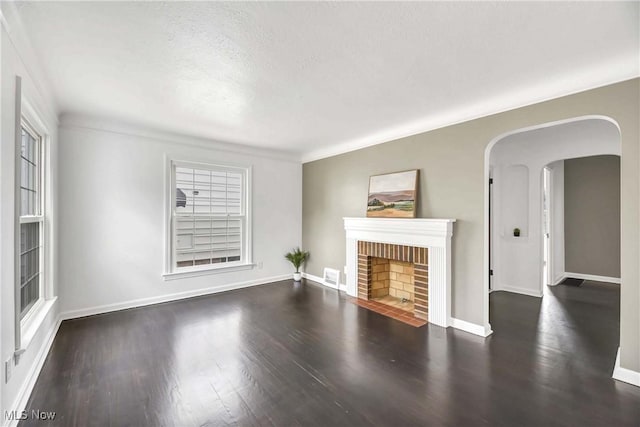 4328 W 56th St, Cleveland, OH 44144 - unfurnished living room with wood finished floors, a fireplace, arched walkways, and a textured ceiling