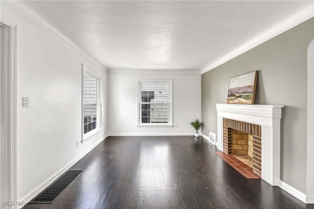 4328 W 56th St, Cleveland, OH 44144 - unfurnished living room featuring a textured ceiling, dark wood finished floors, and a brick fireplace
