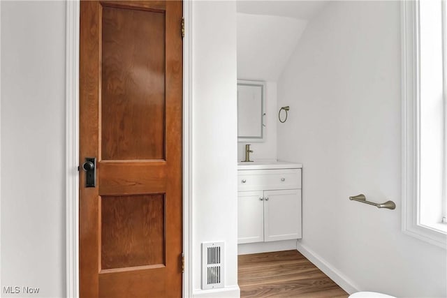 4328 W 56th St, Cleveland, OH 44144 - half bath with vanity, wood finished floors, and vaulted ceiling
