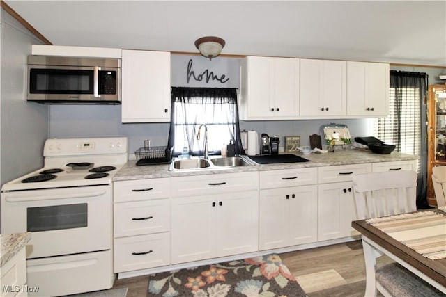1660 N Compass Ave, Port Clinton, OH 43452 - kitchen with white electric range oven, stainless steel microwave, light countertops, white cabinetry, and healthy amount of natural light