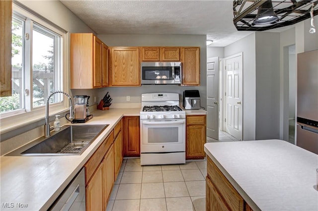 881 Brightwood Ct, Brunswick, OH 44212 - kitchen featuring stainless steel appliances, light countertops, light tile patterned floors, and brown cabinetry