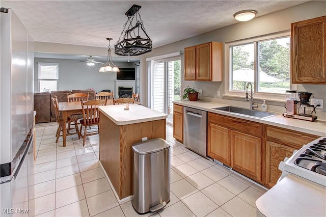 881 Brightwood Ct, Brunswick, OH 44212 - kitchen featuring stainless steel appliances, a fireplace, a kitchen island, open floor plan, and light tile patterned flooring