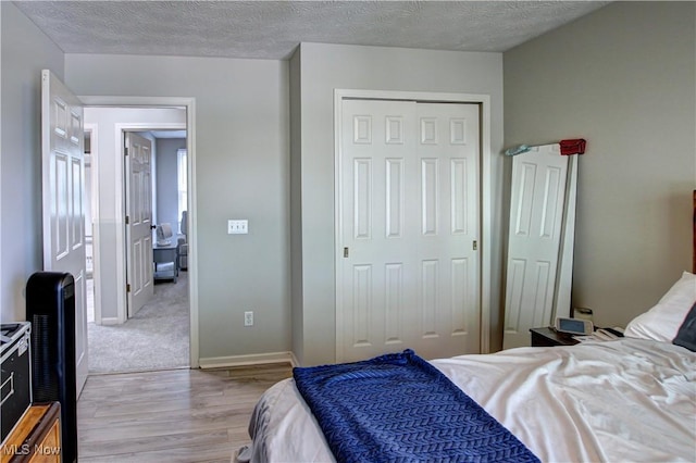 881 Brightwood Ct, Brunswick, OH 44212 - bedroom featuring light wood finished floors, a closet, and a textured ceiling