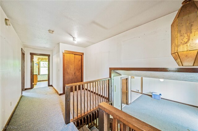 5769 Hurlburt Rd, Rome, OH 44085 - hallway featuring carpet flooring, a textured ceiling, and an upstairs landing