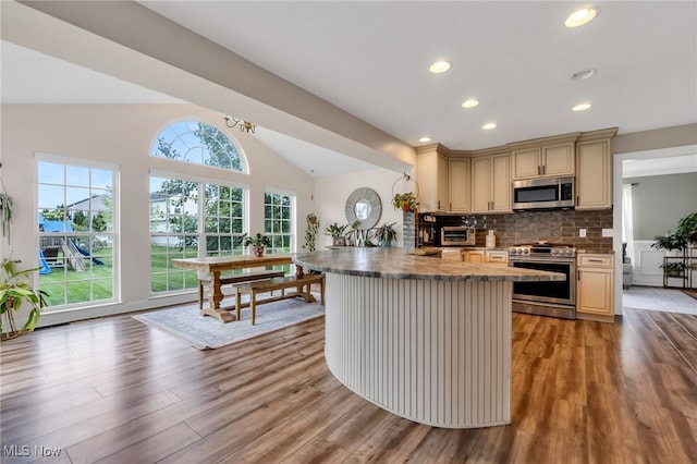 4532 Ridgestone Way, Medina, OH 44256 - kitchen featuring appliances with stainless steel finishes, lofted ceiling, light wood-type flooring, cream cabinets, and decorative backsplash