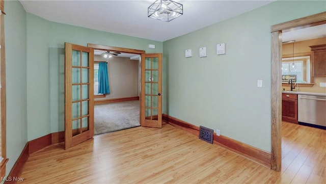 26 Walnut Ct, Mogadore, OH 44260 - empty room with french doors, light wood finished floors, and ceiling fan