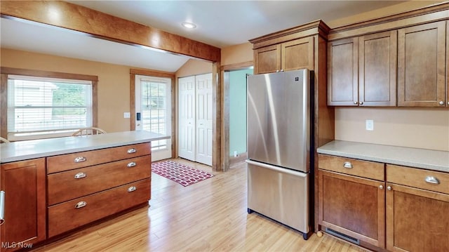 26 Walnut Ct, Mogadore, OH 44260 - kitchen featuring freestanding refrigerator, light wood finished floors, brown cabinetry, and light countertops
