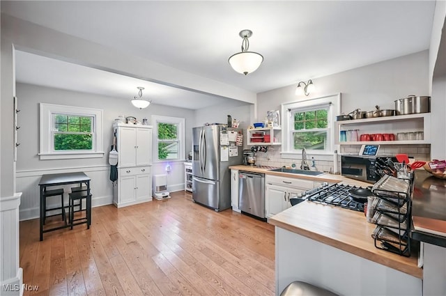1754 Edgewood St NE, Warren, OH 44483 - kitchen with appliances with stainless steel finishes, wood counters, open shelves, light wood-style flooring, and decorative light fixtures
