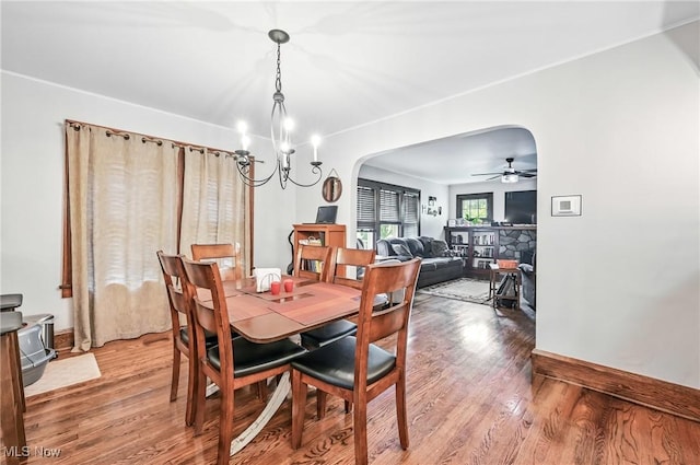 1754 Edgewood St NE, Warren, OH 44483 - dining space with light wood-type flooring, arched walkways, a chandelier, and a ceiling fan