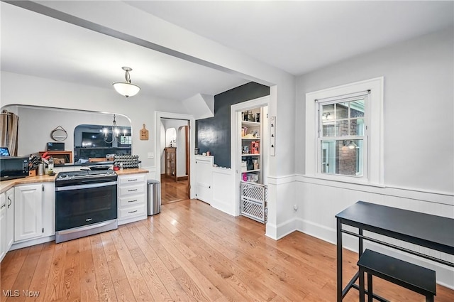 1754 Edgewood St NE, Warren, OH 44483 - kitchen featuring stainless steel gas stove, light countertops, light wood-style floors, white cabinetry, and black microwave