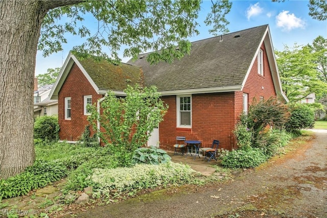 1754 Edgewood St NE, Warren, OH 44483 - rear view of house featuring brick siding, a shingled roof, and a patio