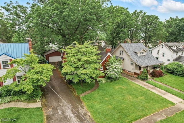 1754 Edgewood St NE, Warren, OH 44483 - view of front of house with a front yard, a chimney, an outbuilding, and view of wooded area