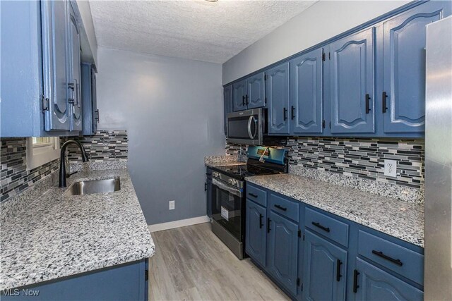 12604 Saint John Ave, Cleveland, OH 44111 - kitchen with appliances with stainless steel finishes, blue cabinetry, and a textured ceiling
