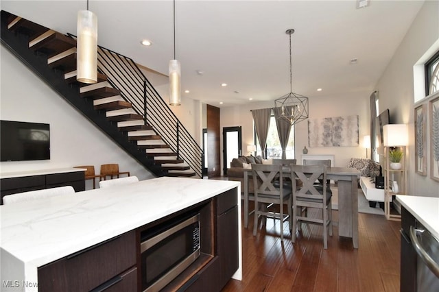 604 Marquardt Ave, Cleveland, OH 44113 - kitchen featuring open floor plan, appliances with stainless steel finishes, dark brown cabinets, a chandelier, and dark wood-style floors