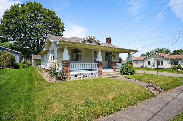 608 S 14th St, Sebring, OH 44672 - view of front of house featuring covered porch, a chimney, and a front yard