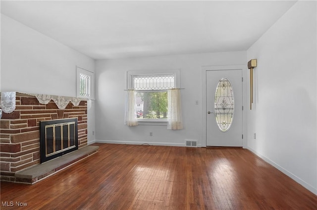 608 S 14th St, Sebring, OH 44672 - unfurnished living room featuring wood-type flooring and a fireplace