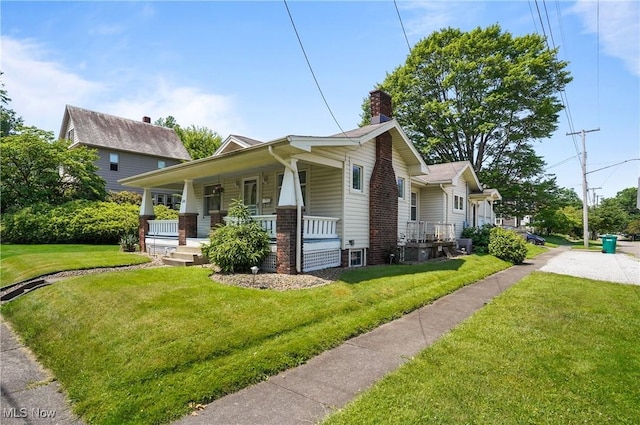 608 S 14th St, Sebring, OH 44672 - view of side of property featuring a chimney, a porch, a yard, and brick siding