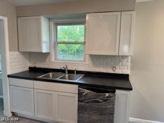 5357 Beechwood Ave, Maple Heights, OH 44137 - kitchen featuring black dishwasher, dark countertops, tasteful backsplash, and white cabinetry