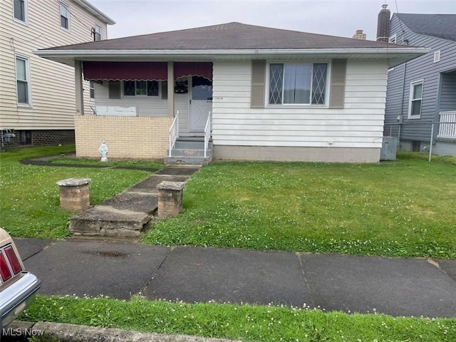 12011/2 N 5th St, Toronto, OH 43964 - view of front of property with a front yard, a shingled roof, and entry steps