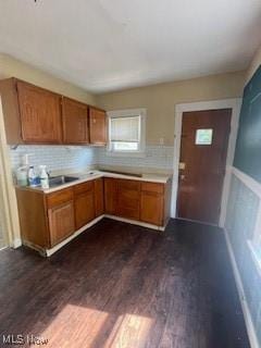 4313 Wichita Ave, Cleveland, OH 44109 - kitchen featuring brown cabinetry, dark wood finished floors, light countertops, and plenty of natural light