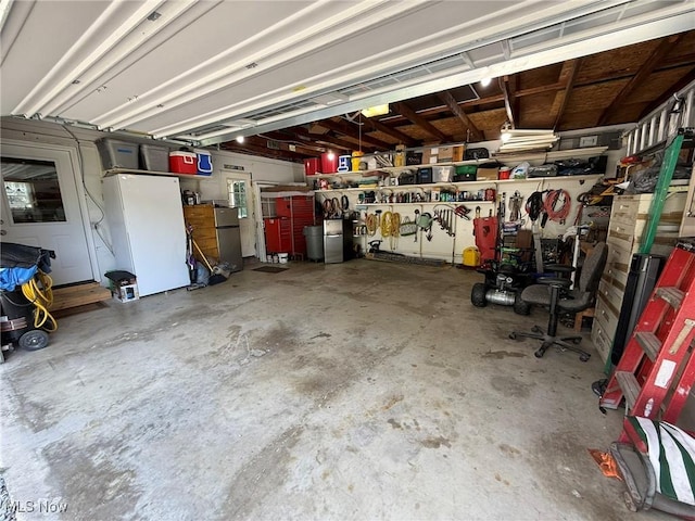 22399 Township Rd Unit 1203, West Lafayette, OH 43845 - garage with freestanding refrigerator and a workshop area