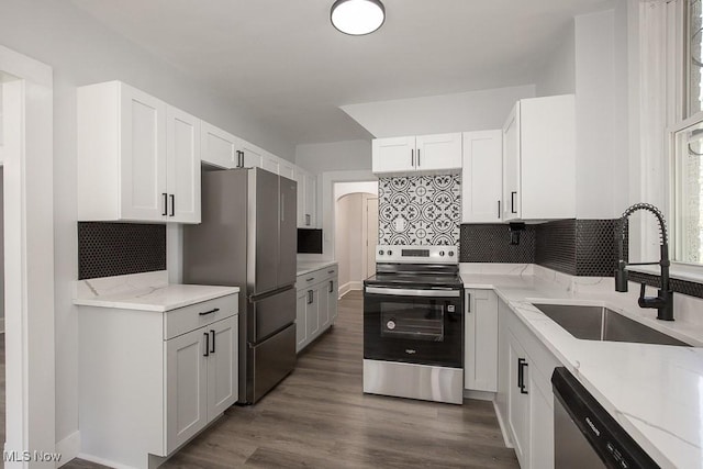 381 Watson St, Akron, OH 44305 - kitchen with stainless steel appliances, light stone countertops, decorative backsplash, white cabinetry, and dark wood-style flooring