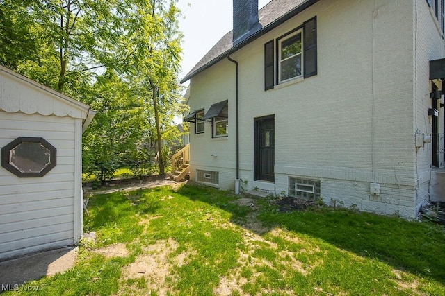 381 Watson St, Akron, OH 44305 - view of home's exterior featuring a lawn, a chimney, and entry steps