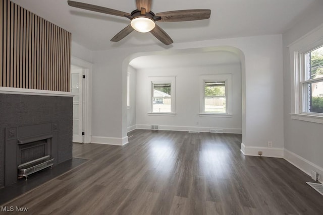 381 Watson St, Akron, OH 44305 - unfurnished living room with arched walkways, a fireplace with flush hearth, dark wood-style floors, and ceiling fan