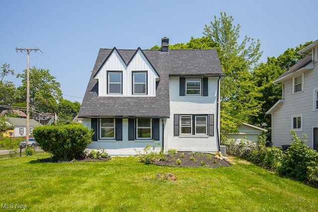 381 Watson St, Akron, OH 44305 - view of front of house with a front yard, roof with shingles, a chimney, board and batten siding, and brick siding