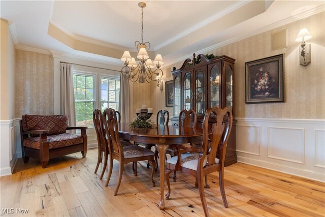 1588 Eagle Watch St NE, Canton, OH 44721 - dining area featuring wallpapered walls, a chandelier, light wood-type flooring, wainscoting, and crown molding