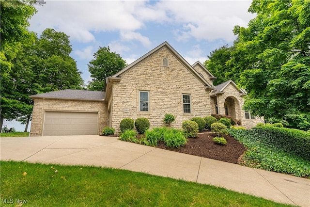 1588 Eagle Watch St NE, Canton, OH 44721 - view of front of house featuring stone siding, a garage, and concrete driveway