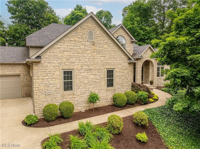 1588 Eagle Watch St NE, Canton, OH 44721 - view of front facade featuring stone siding, a shingled roof, and concrete driveway