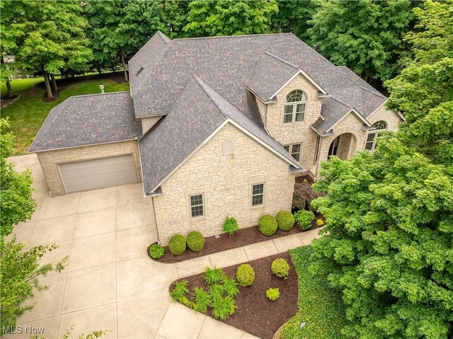 1588 Eagle Watch St NE, Canton, OH 44721 - view of front of home featuring stone siding, roof with shingles, concrete driveway, and an attached garage