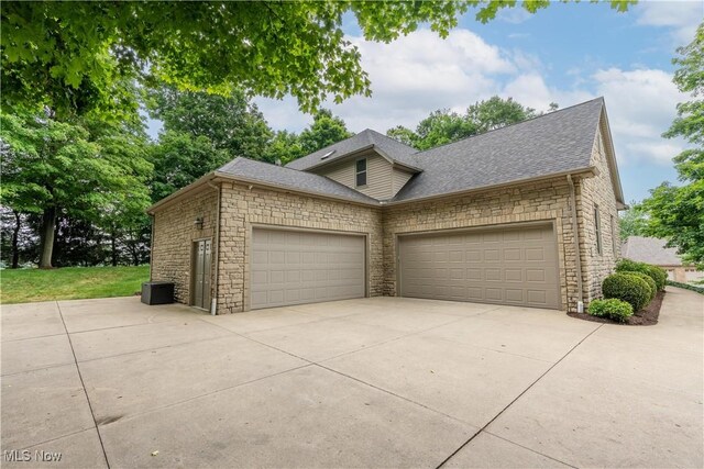 1588 Eagle Watch St NE, Canton, OH 44721 - view of front of property with stone siding, roof with shingles, a garage, and driveway