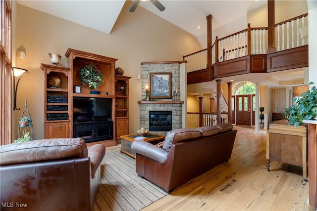 1588 Eagle Watch St NE, Canton, OH 44721 - living room featuring a ceiling fan, light wood finished floors, a fireplace, high vaulted ceiling, and ornate columns