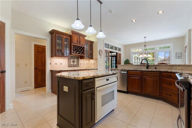 1588 Eagle Watch St NE, Canton, OH 44721 - kitchen featuring stainless steel appliances, light tile patterned floors, backsplash, glass insert cabinets, and recessed lighting