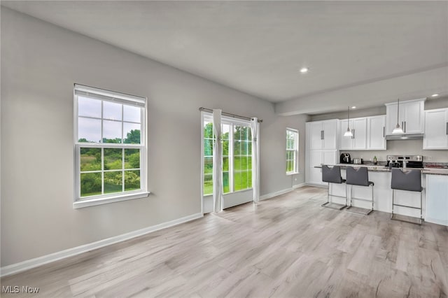 1633 Duncan Way, Streetsboro, OH 44241 - kitchen featuring stainless steel range with electric cooktop, white cabinetry, light wood finished floors, under cabinet range hood, and a kitchen breakfast bar