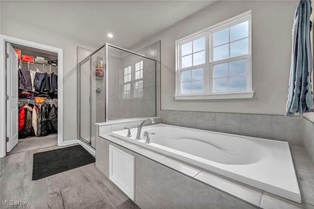 1633 Duncan Way, Streetsboro, OH 44241 - bathroom with a bath, a stall shower, a walk in closet, and wood finished floors