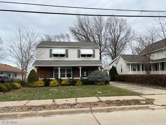 1531 E 290th St, Wickliffe, OH 44092 - traditional-style home featuring a porch, a front lawn, and driveway