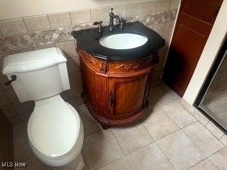 1531 E 290th St, Wickliffe, OH 44092 - bathroom with vanity, tile walls, tile patterned flooring, and a shower with door