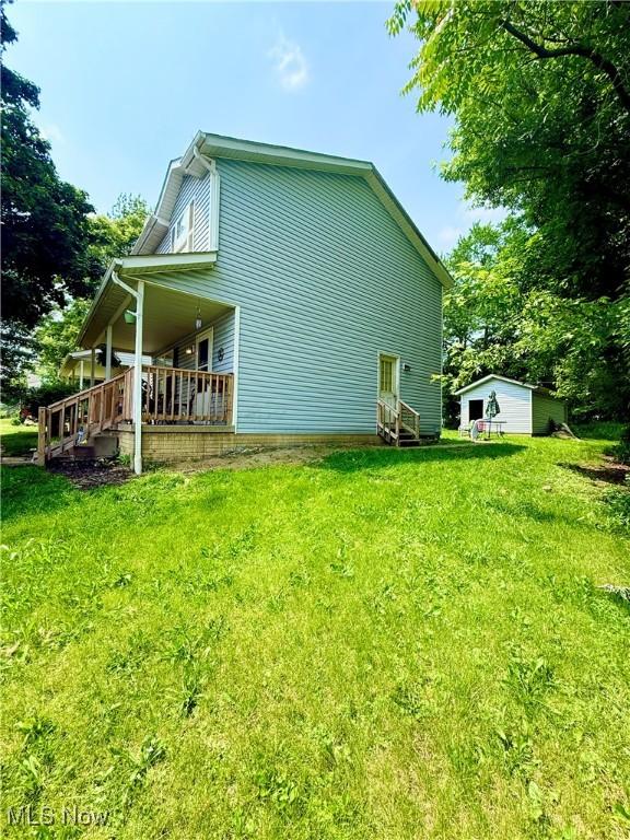 732 E High St, Alliance, OH 44601 - view of home's exterior featuring a lawn, a porch, an outbuilding, and entry steps