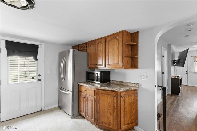 1309 7th St N, Martins Ferry, OH 43935 - kitchen featuring appliances with stainless steel finishes, arched walkways, brown cabinetry, and open shelves