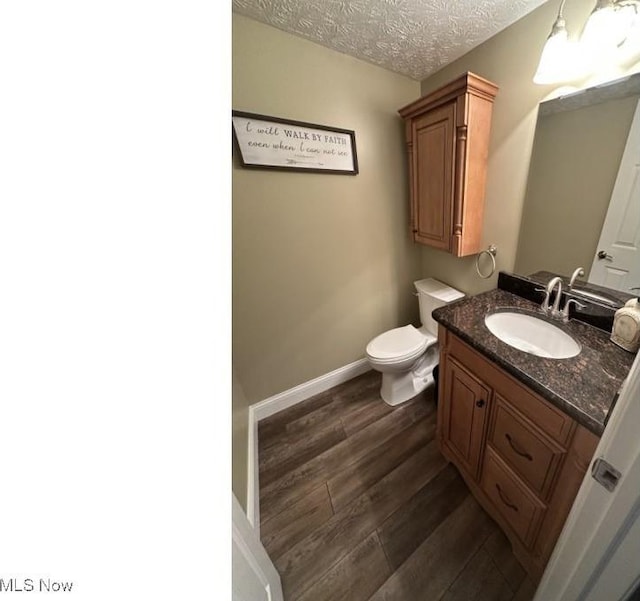 324 Buttermere Ln, Amherst, OH 44001 - half bathroom featuring vanity, wood finished floors, and a textured ceiling