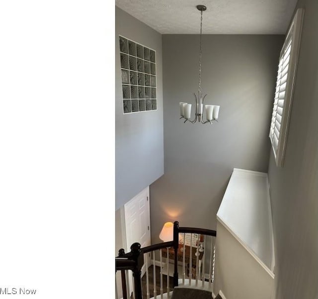 324 Buttermere Ln, Amherst, OH 44001 - stairway with a chandelier and a textured ceiling