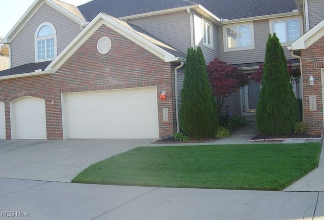 324 Buttermere Ln, Amherst, OH 44001 - view of front of property with brick siding, driveway, and a front lawn