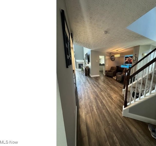 324 Buttermere Ln, Amherst, OH 44001 - corridor with dark wood finished floors, a textured ceiling, and stairs