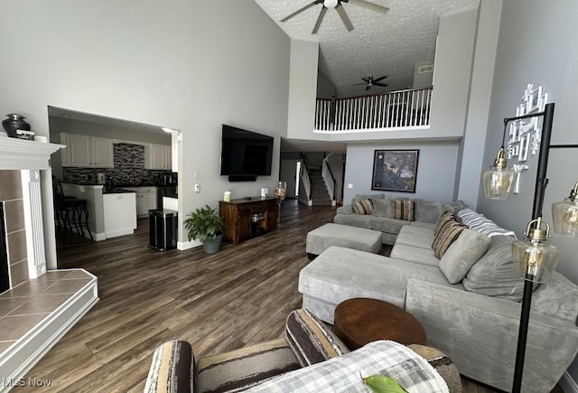 324 Buttermere Ln, Amherst, OH 44001 - living room with high vaulted ceiling, ceiling fan, dark wood-style flooring, stairs, and a textured ceiling